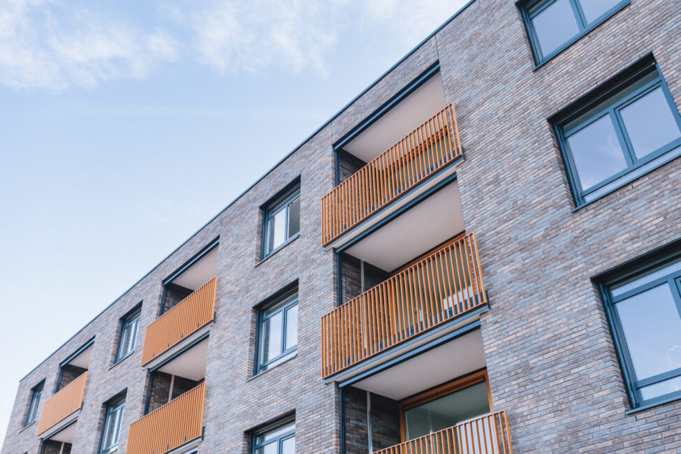 Moderne appartementencomplex met bakstenen gevel en houten balkons tegen een blauwe lucht in Zwijndrecht, Nederland.