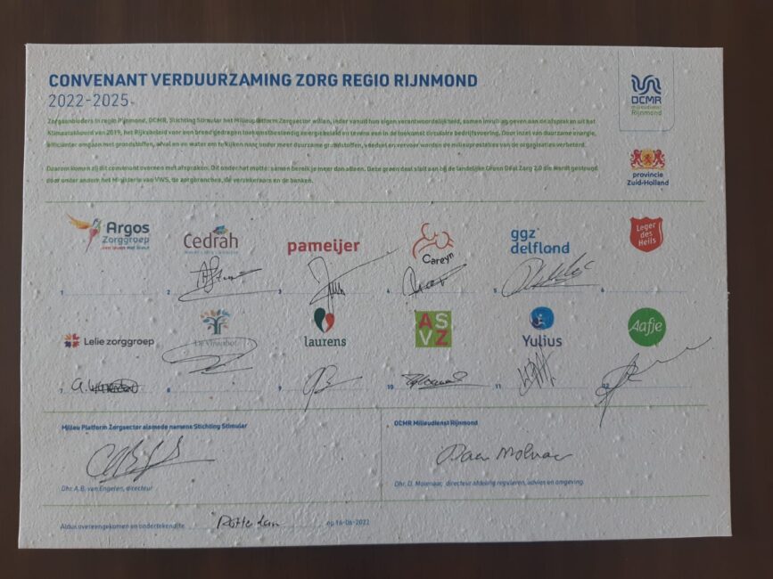 Afbeelding van een ondertekend convenant voor verduurzaming in de zorgregio Rijnmond, met diverse logo's en handtekeningen.
