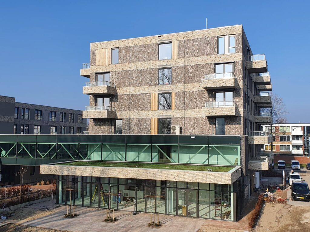 Nieuwbouw appartementencomplex Bloesemhove met moderne architectuur, grote ramen en balkons, onder een heldere blauwe lucht.