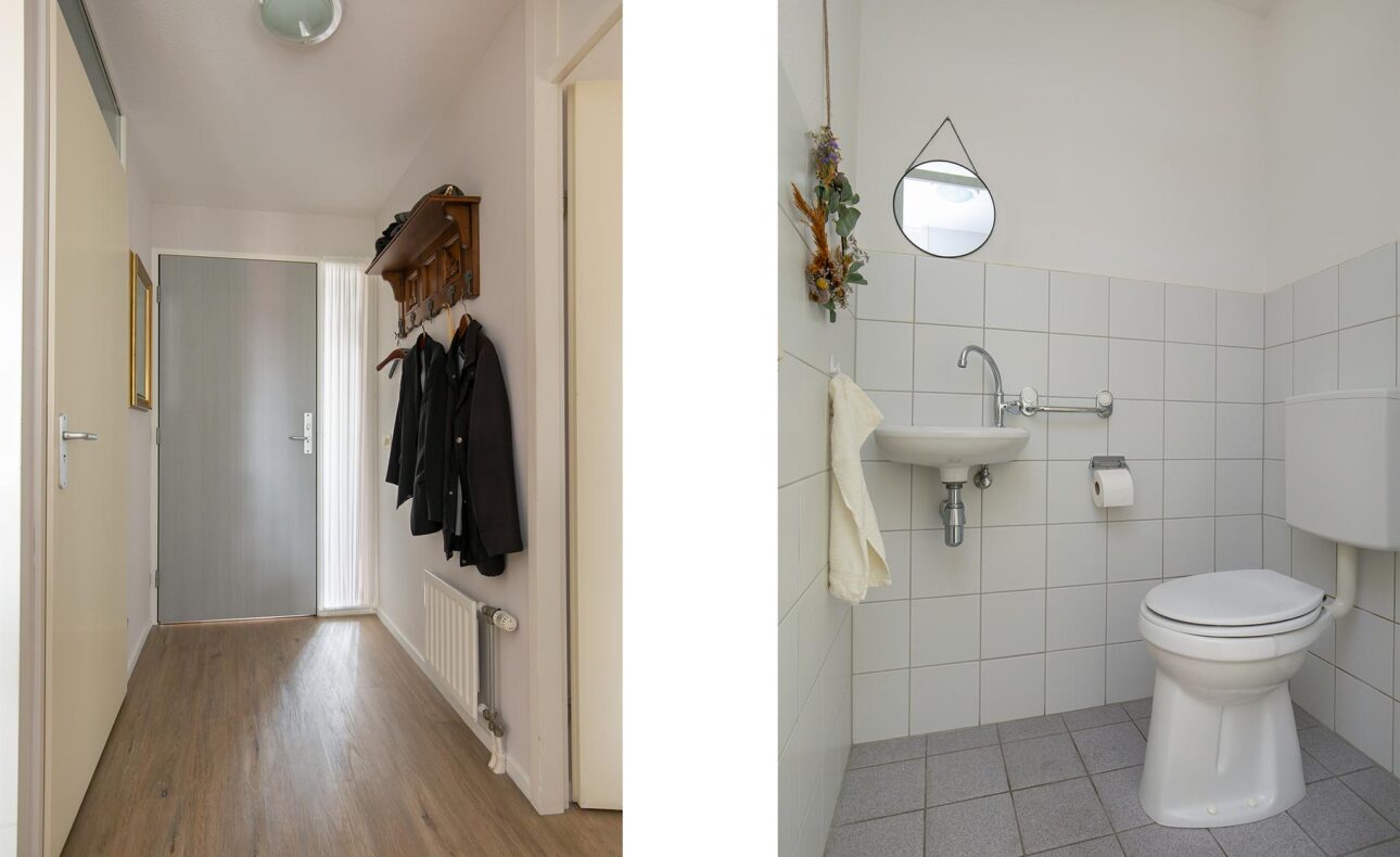 Afbeelding van een smalle gang met houten vloer en jassen aan de kapstok, naast een kleine, betegelde badkamer met toilet en wastafel.