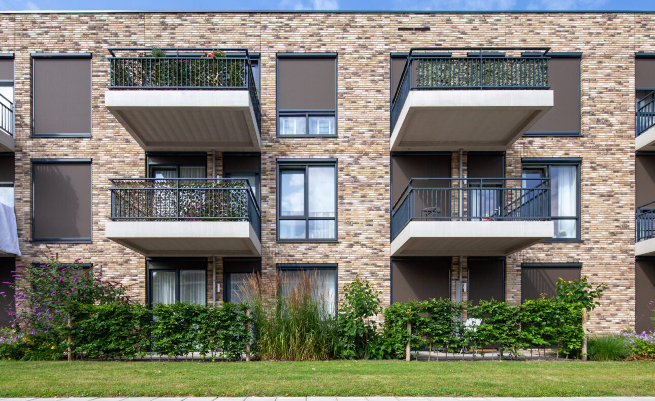 Foto van de gevel van Marnix Staete. Op de foto zijn enkele appartementen te zien met aangrenzend het balkon. De gevel heeft een gemêleerde steen en op de begane grond is een tuin aangeplant.