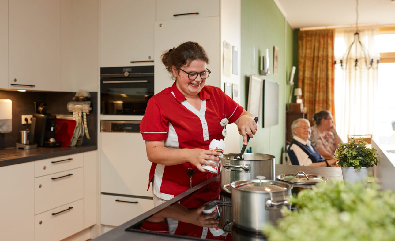 Zorgmedewerker die eten aan het koken is.