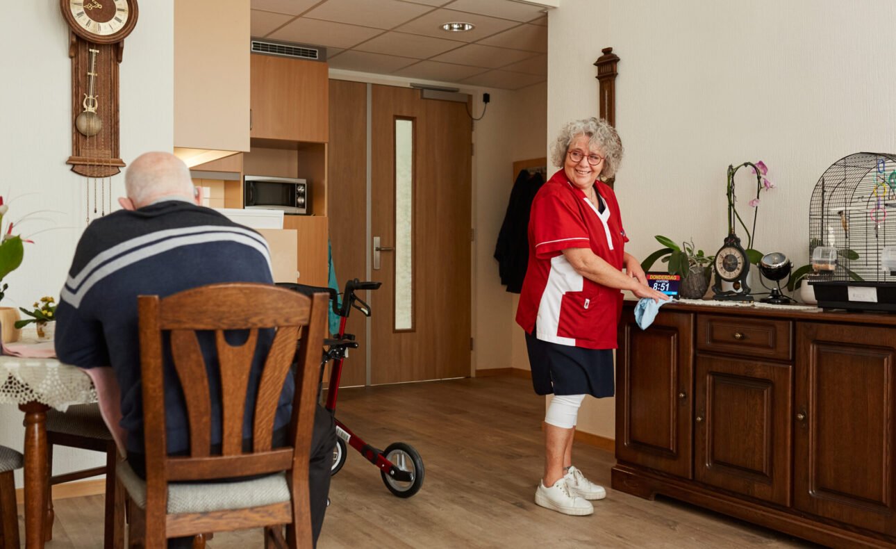 Huishoudelijk medewerker is aan het schoonmaken in een appartement van een bewoner.