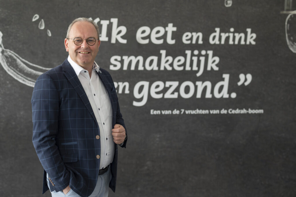 Man voor muur met tekst 'ik eet en drink smakelijk en gezond'