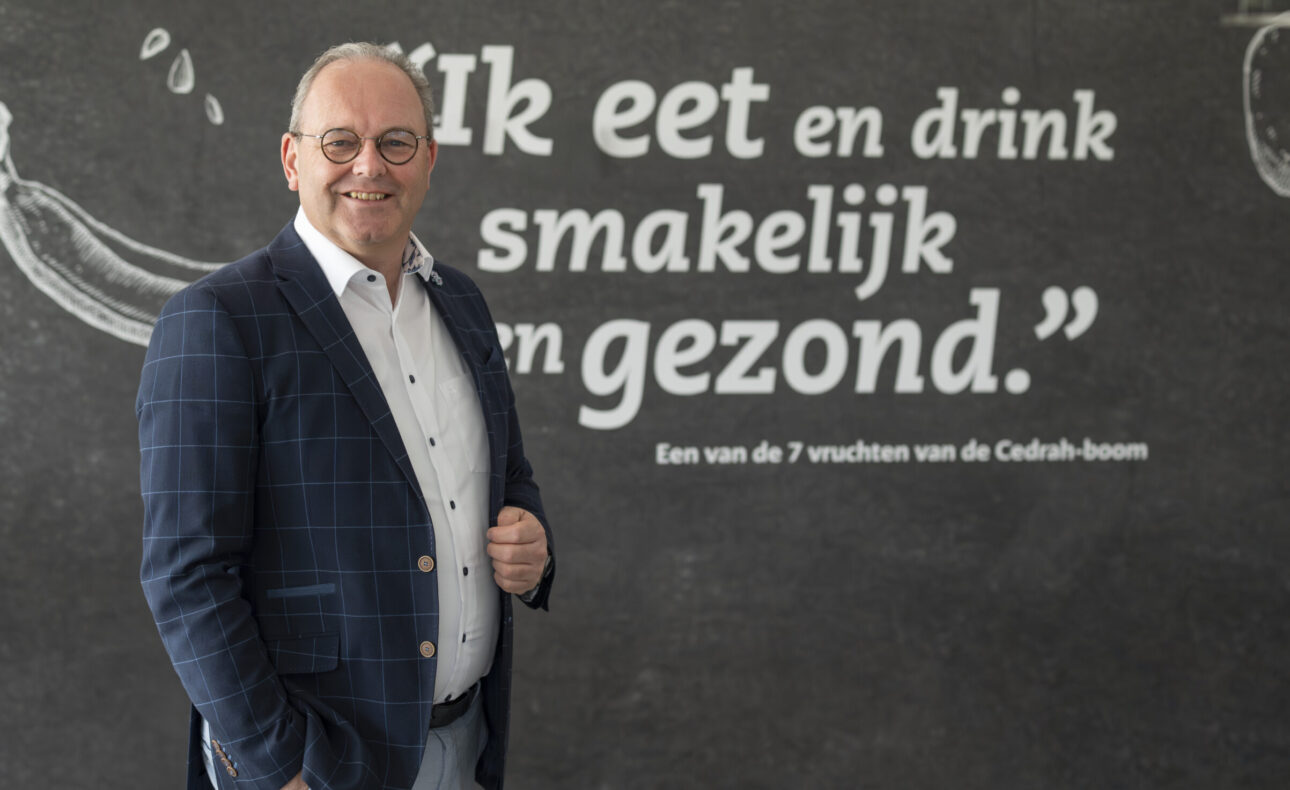 Man voor muur met tekst 'ik eet en drink smakelijk en gezond'