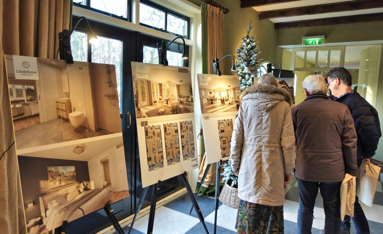 Bezoekers bekijken de plattegronden op schildersezels