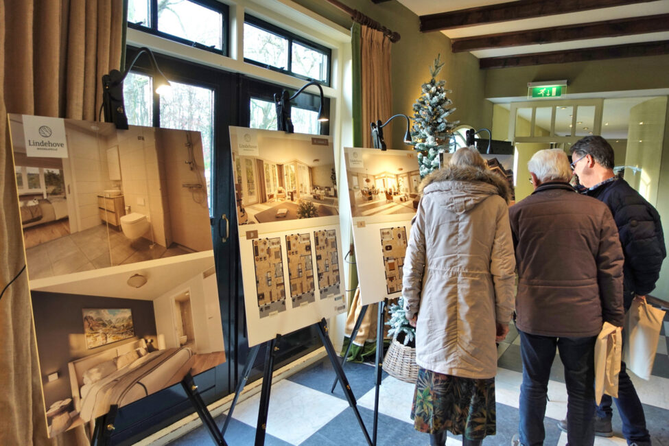 Bezoekers bekijken de plattegronden op schildersezels