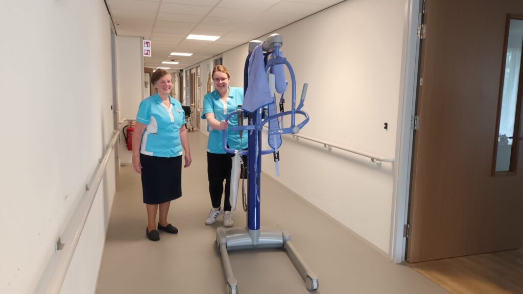 Twee zorgmedewerkers in gang met tillift.