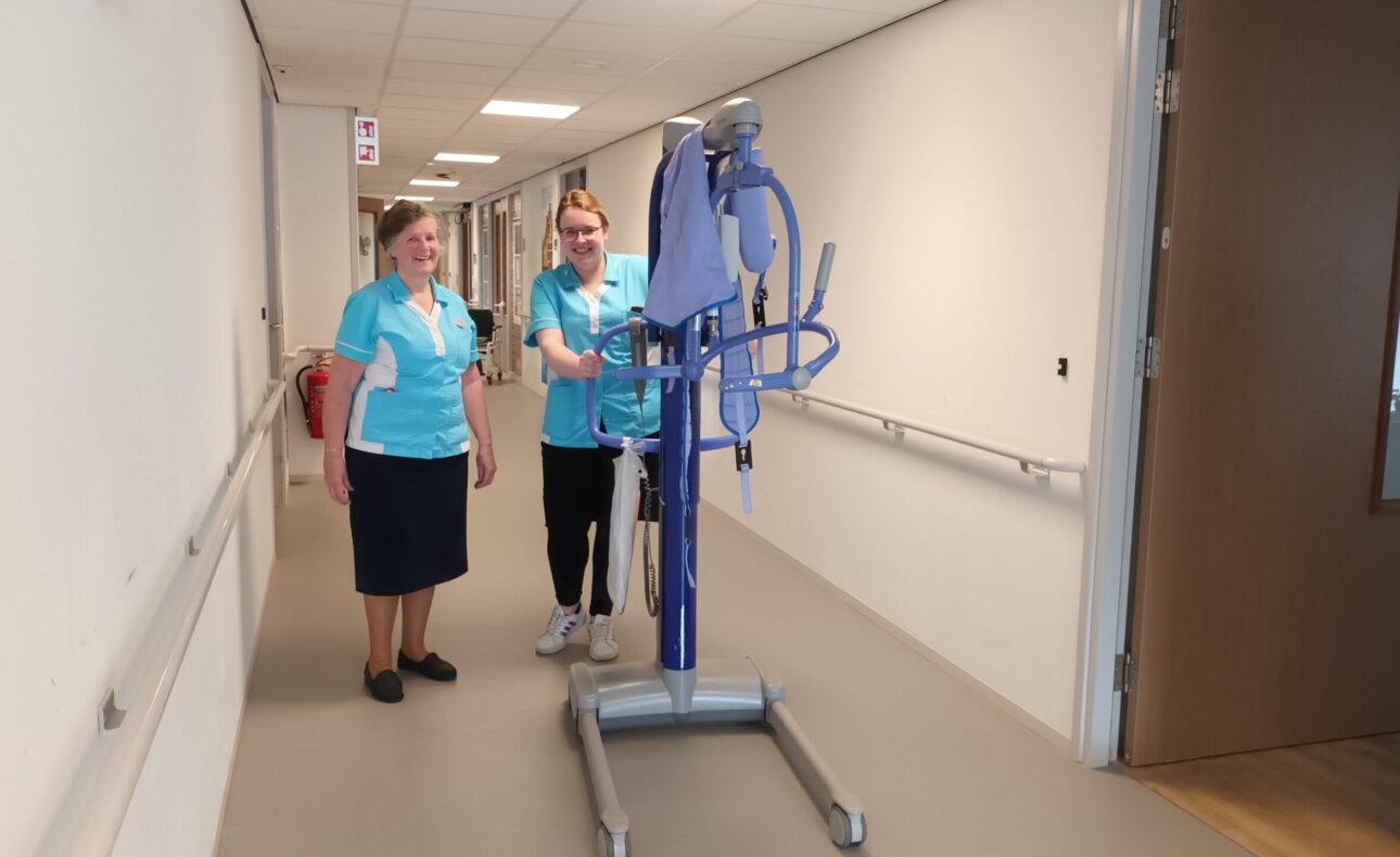 Twee zorgmedewerkers in gang met tillift.