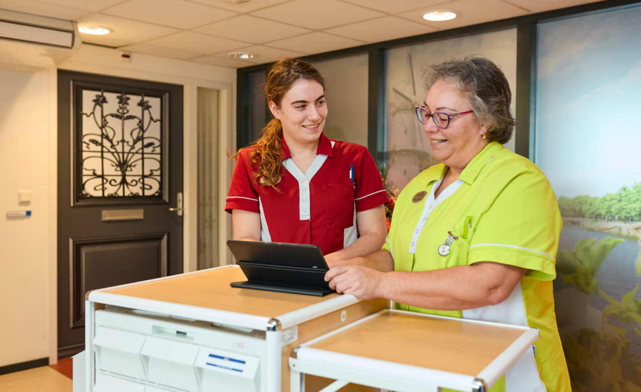 Twee zorgmedewerkers van Cedrah bij een medicijnkar