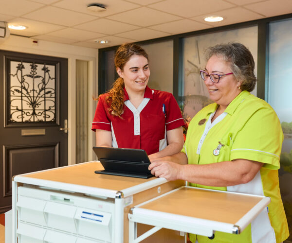 Twee zorgmedewerkers van Cedrah bij een medicijnkar