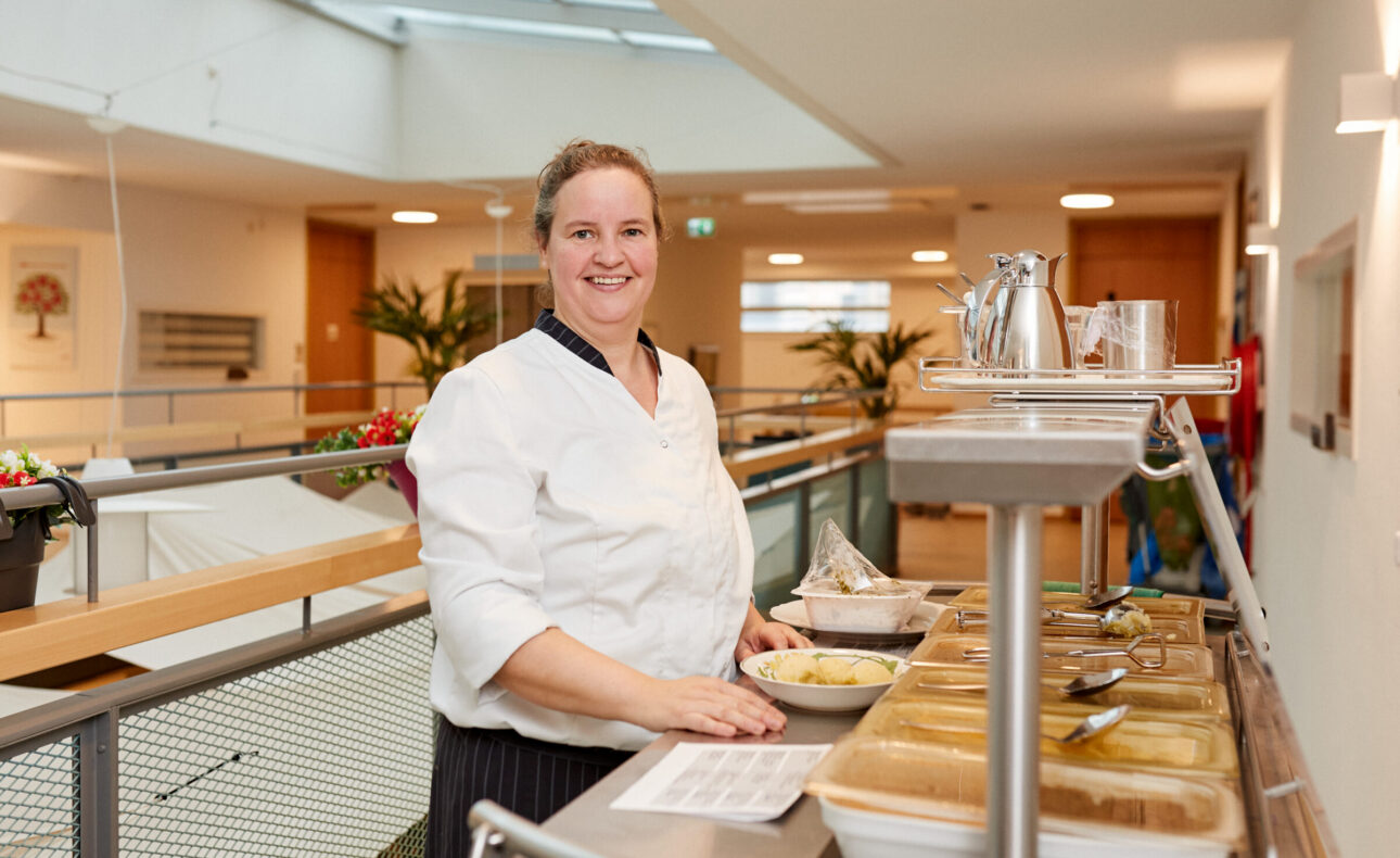 Medewerkster voedingsdienst deelt maaltijden uit in het woonzorgcentrum