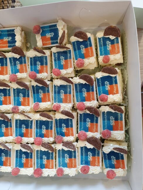 Een doos vol gebakjes met daarop 'ChristenUnie-SGP Vlaardingen'