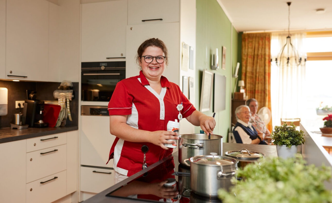 Een zorgmedewerkers is aan het koken.