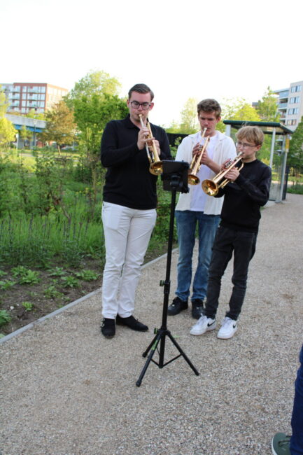 Drie jongens spelen buiten trompet
