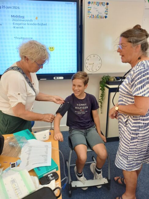 Twee dames nemen de bloeddruk op bij een jongen