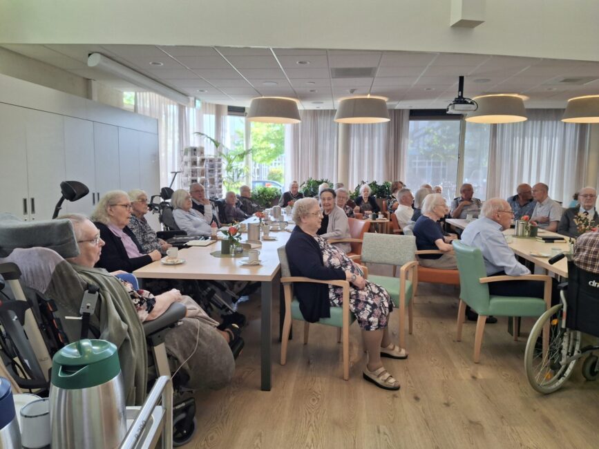 Ouderen in een zaal luisteren
