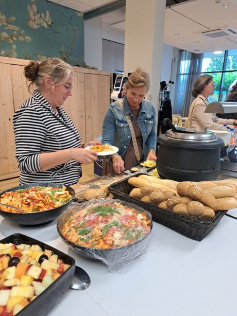 Vrouwen scheppen eten op bij een buffet
