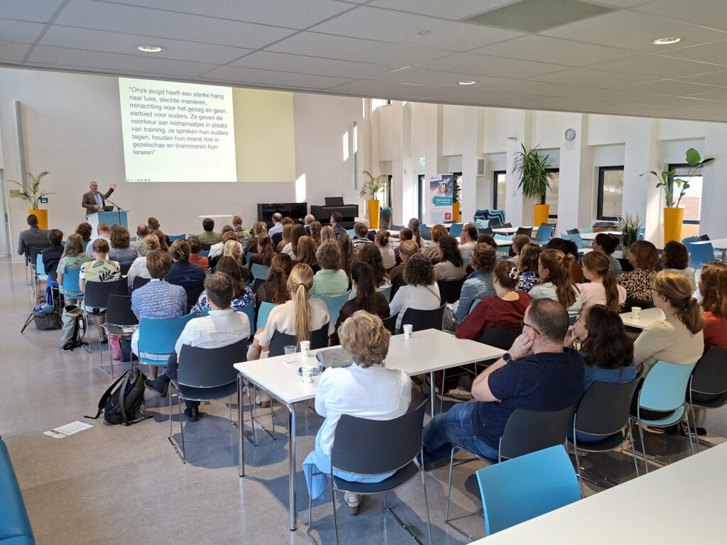 Mensen in een zaal luisteren naar een presentatie