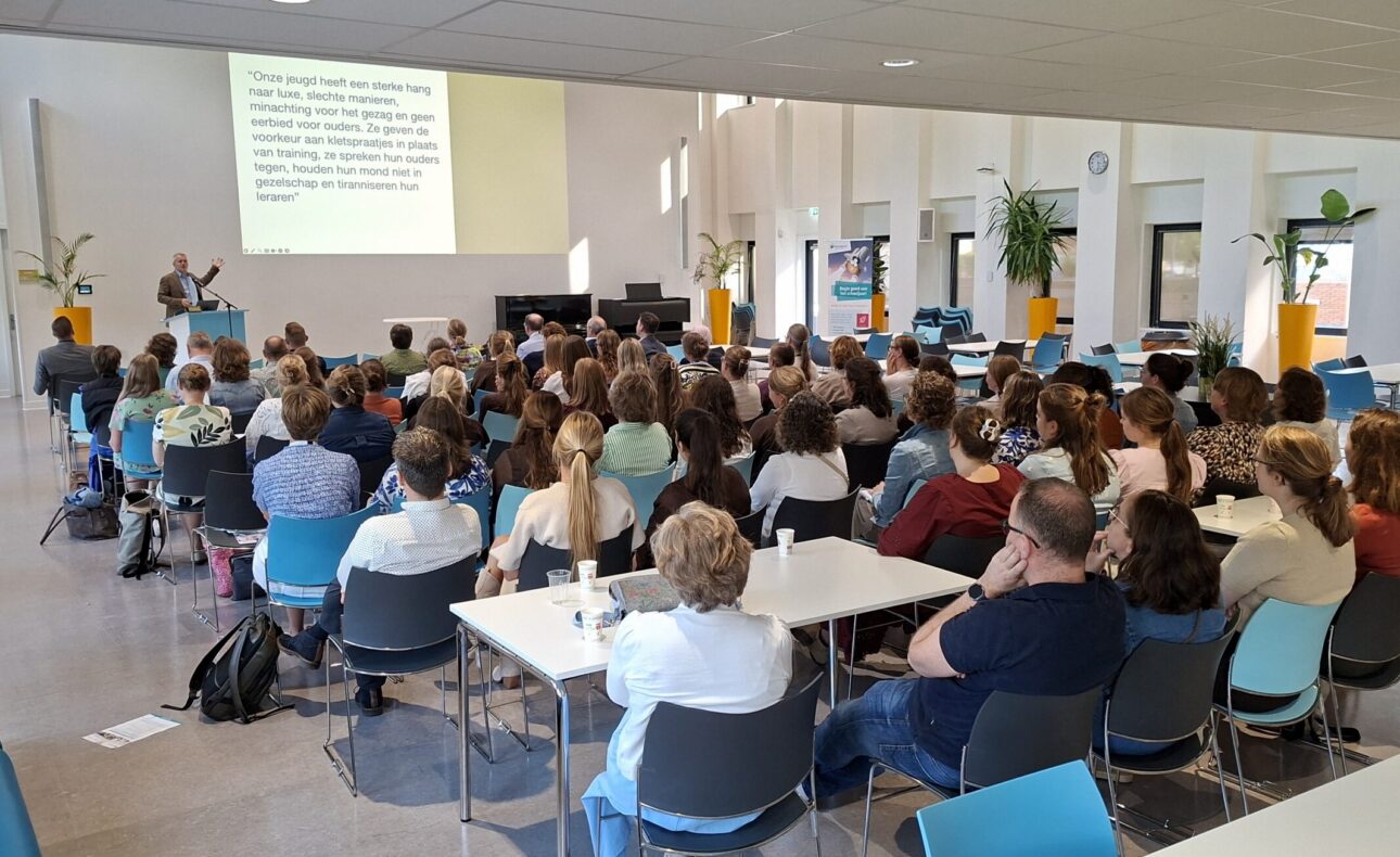 Mensen in een zaal luisteren naar een presentatie
