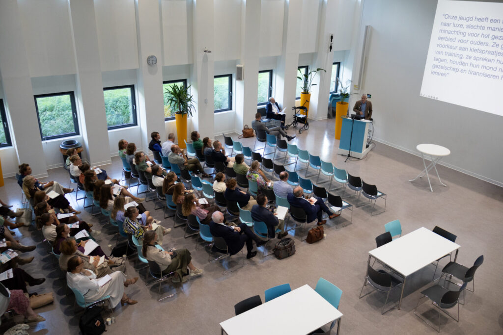 Mensen in een zaal luisteren naar een presentatie