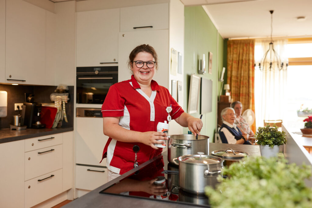 Zorgmedewerker is aan het koken op de huiskamer